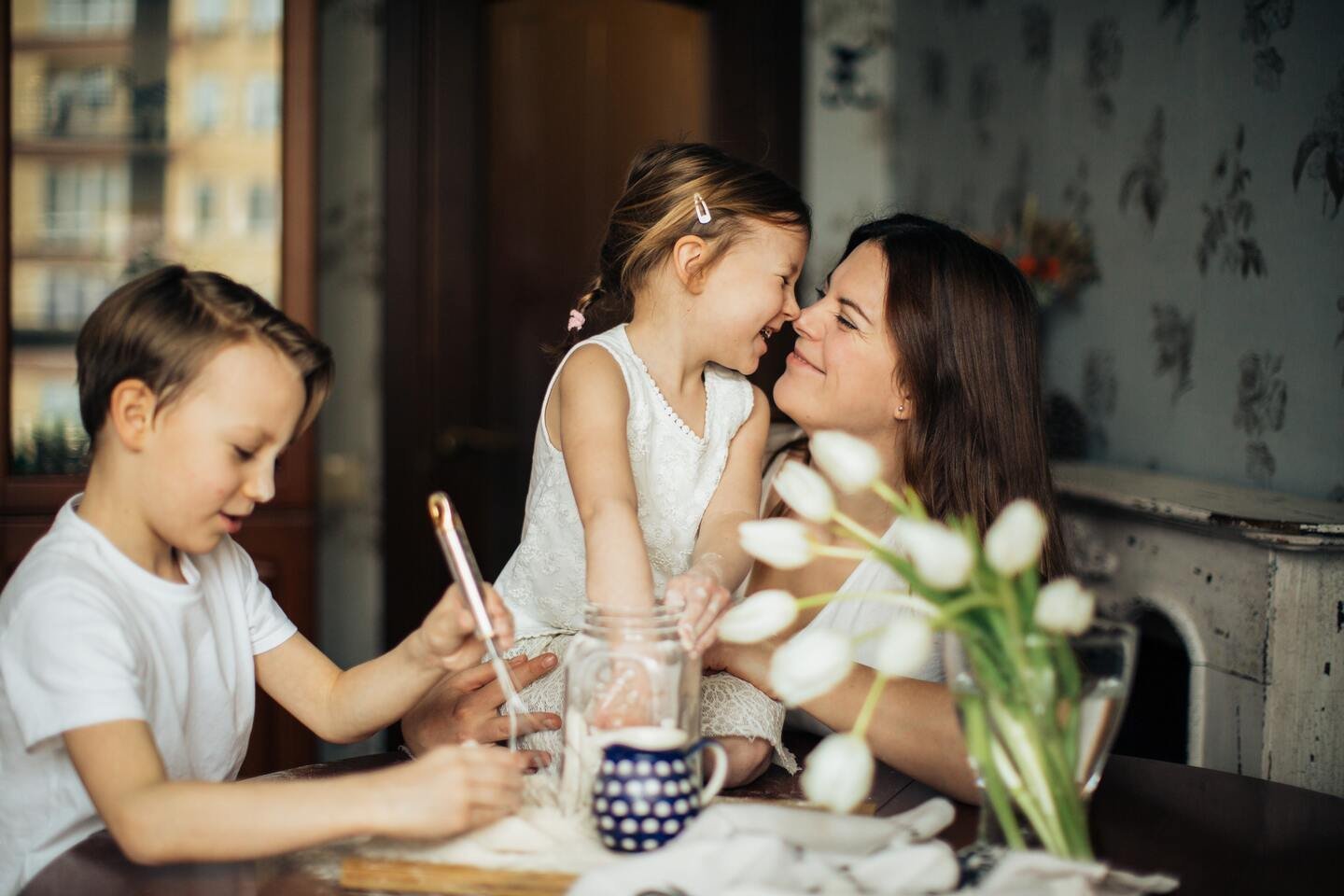 Mulher e duas crianças à mesa, imagem original do artigo Como ensinar valores?